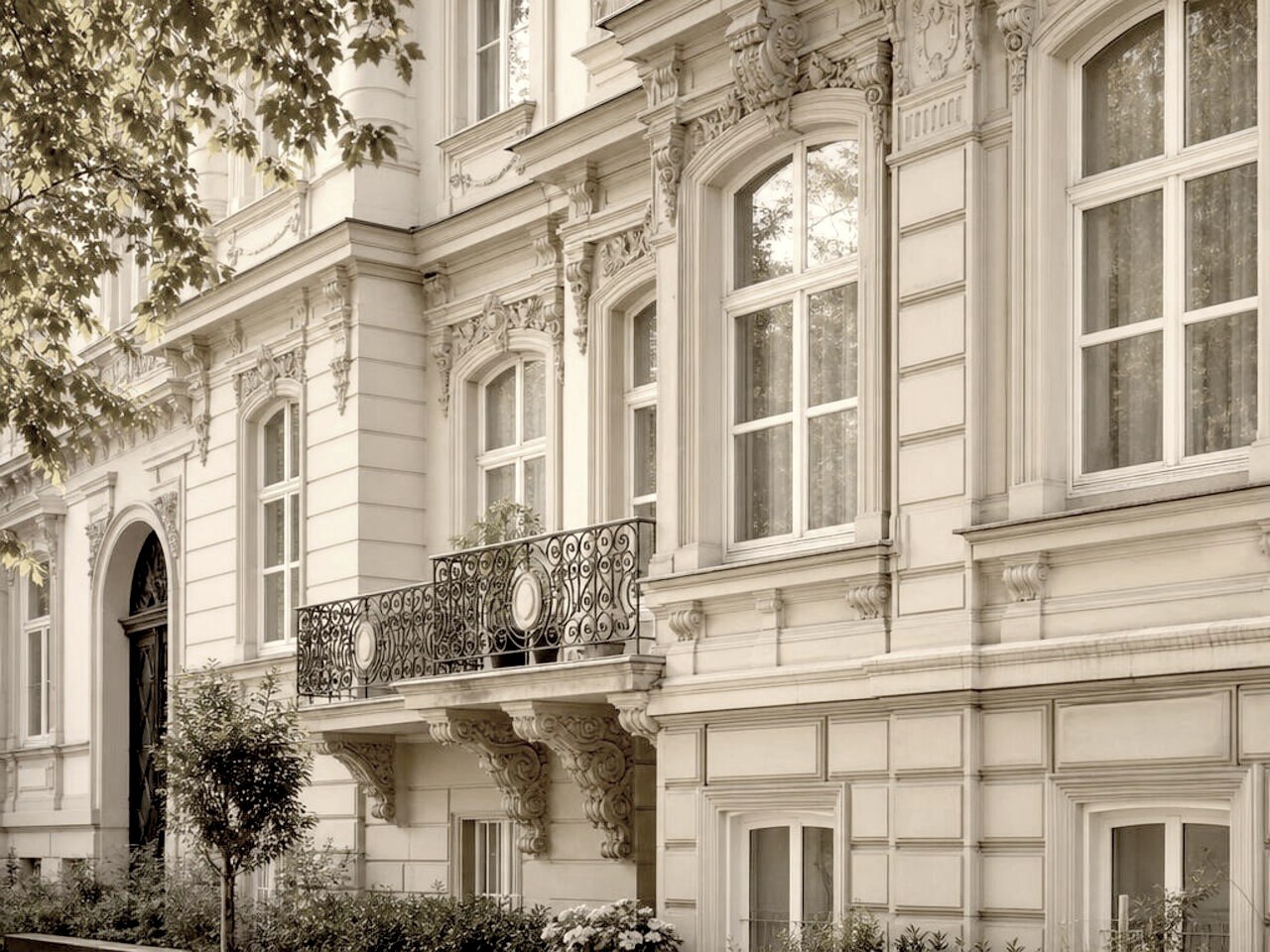 Historische Altbau-Fassade mit Stuckdetails und hohen Fensterbögen
